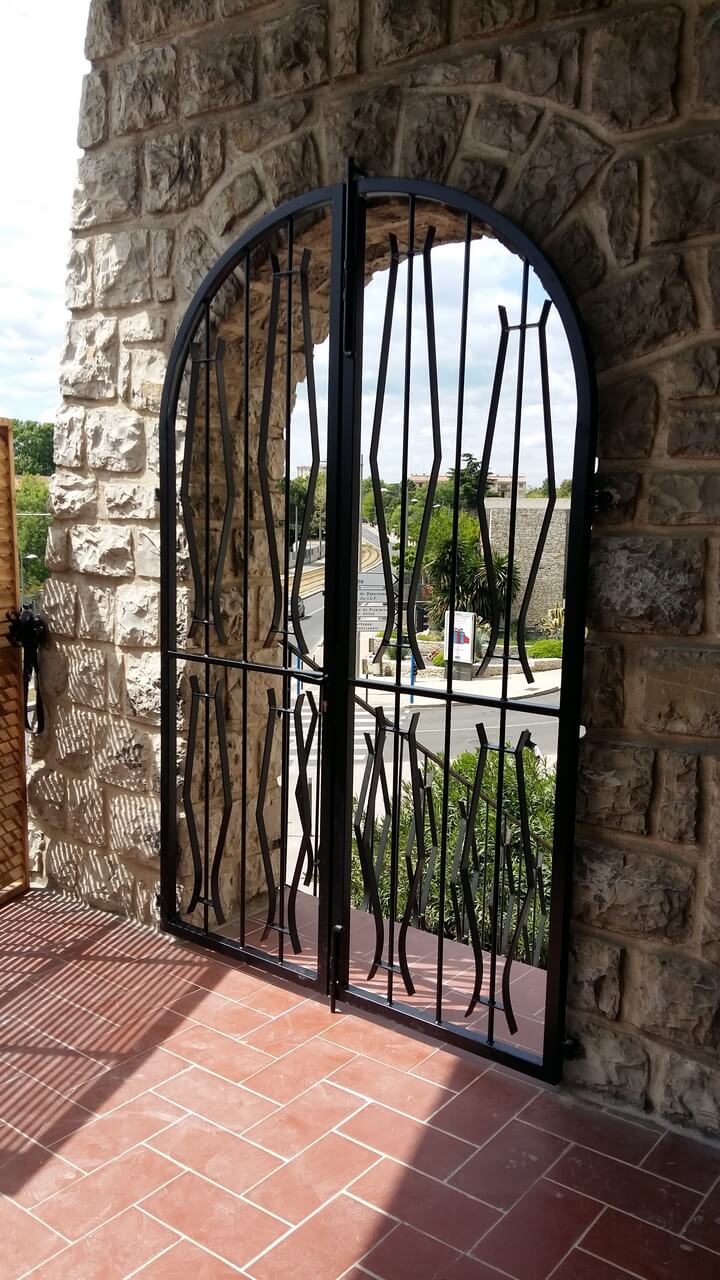 Porte double grille en arche vue terrasse Métal'Rine